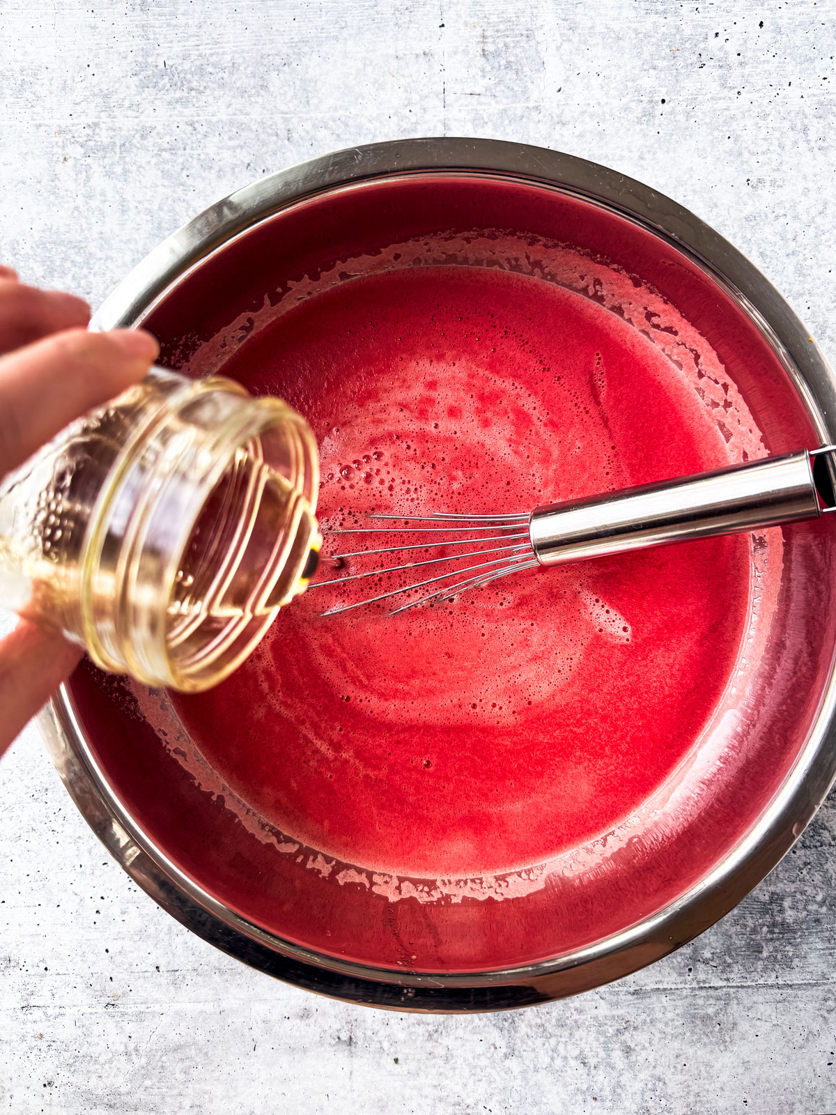 Simple syrup being added to watermelon purée.