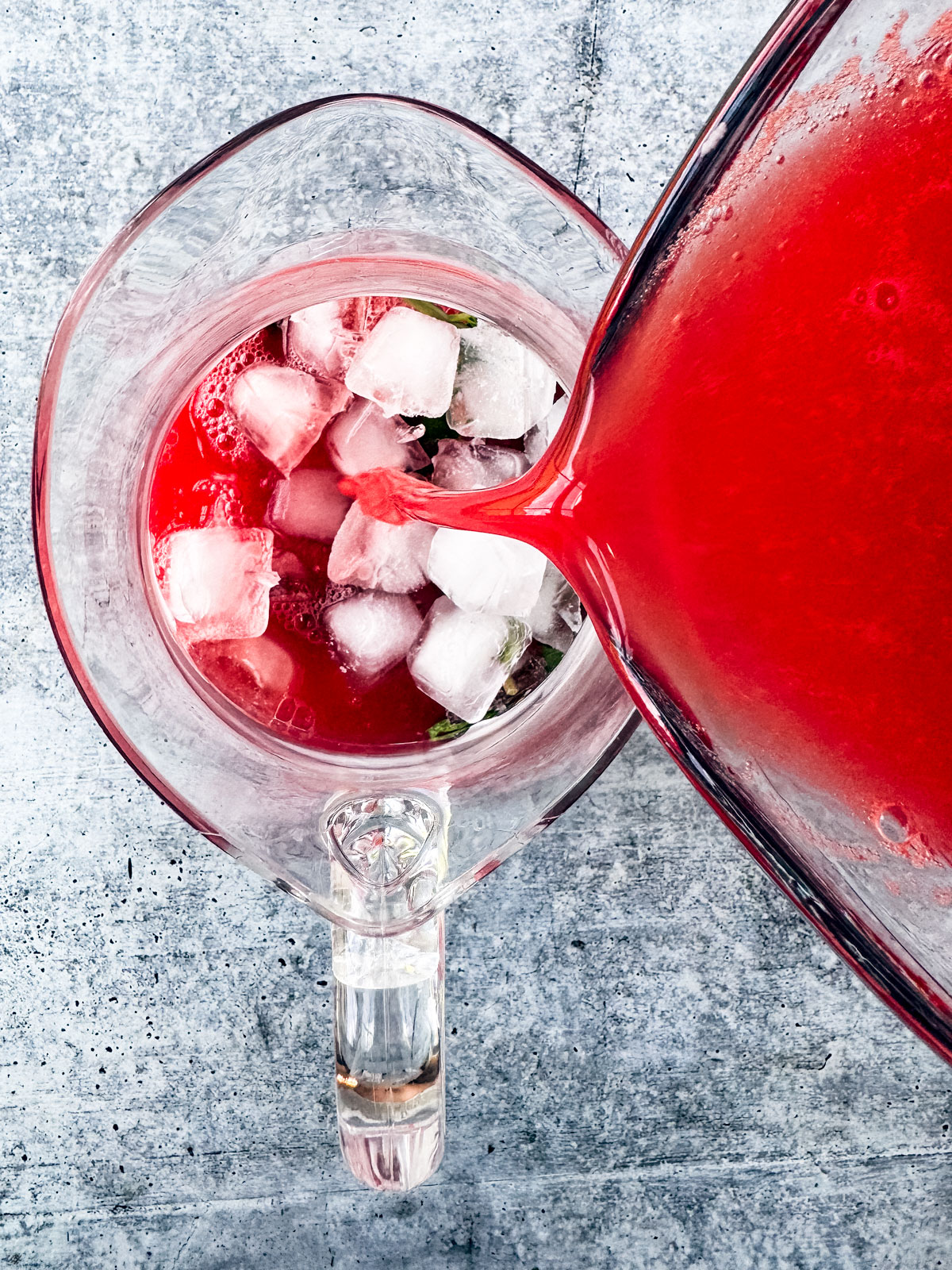 Watermelon being poured into a pitcher of ice.