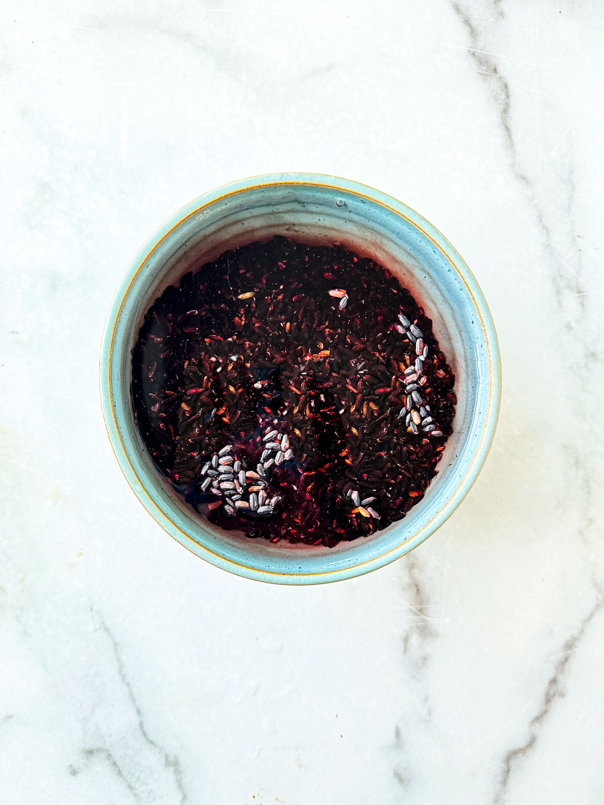 Black rice being soaked in cold water.