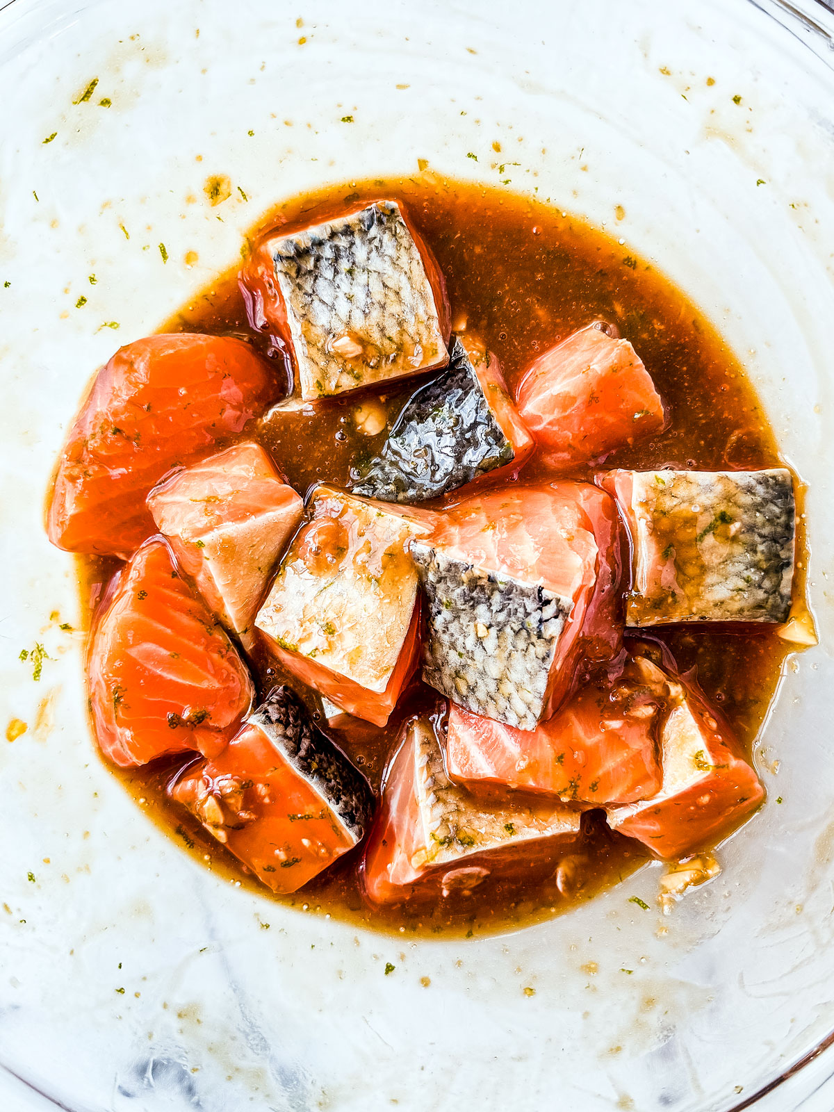 Salmon cubes marinating in a mixing bowl.