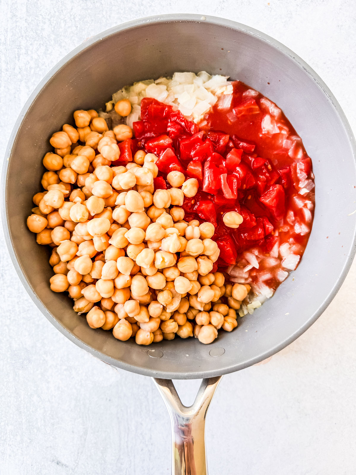 Chickpeas and tomatoes added to the skillet.