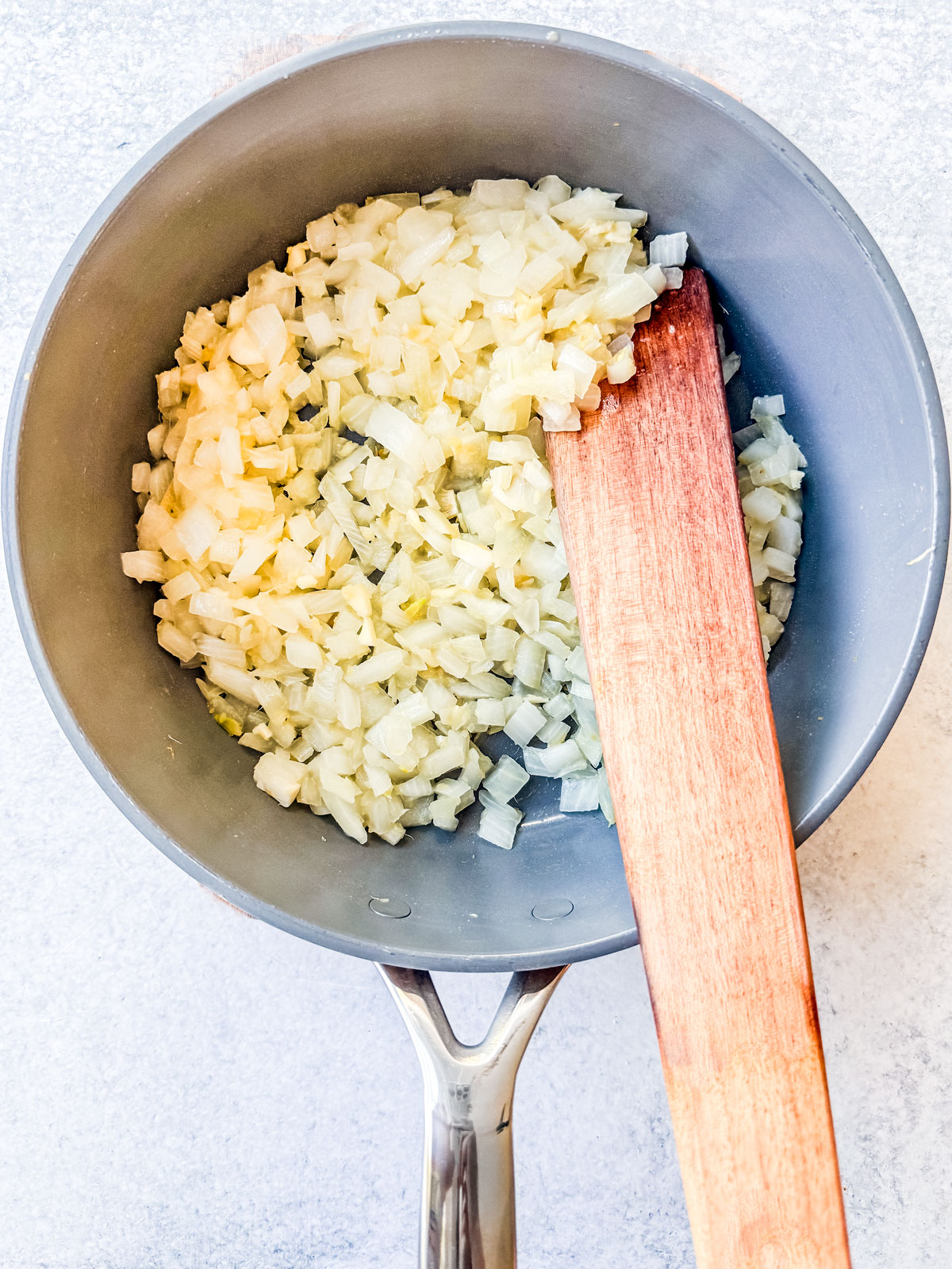 Onions being sautéd in a skillet.