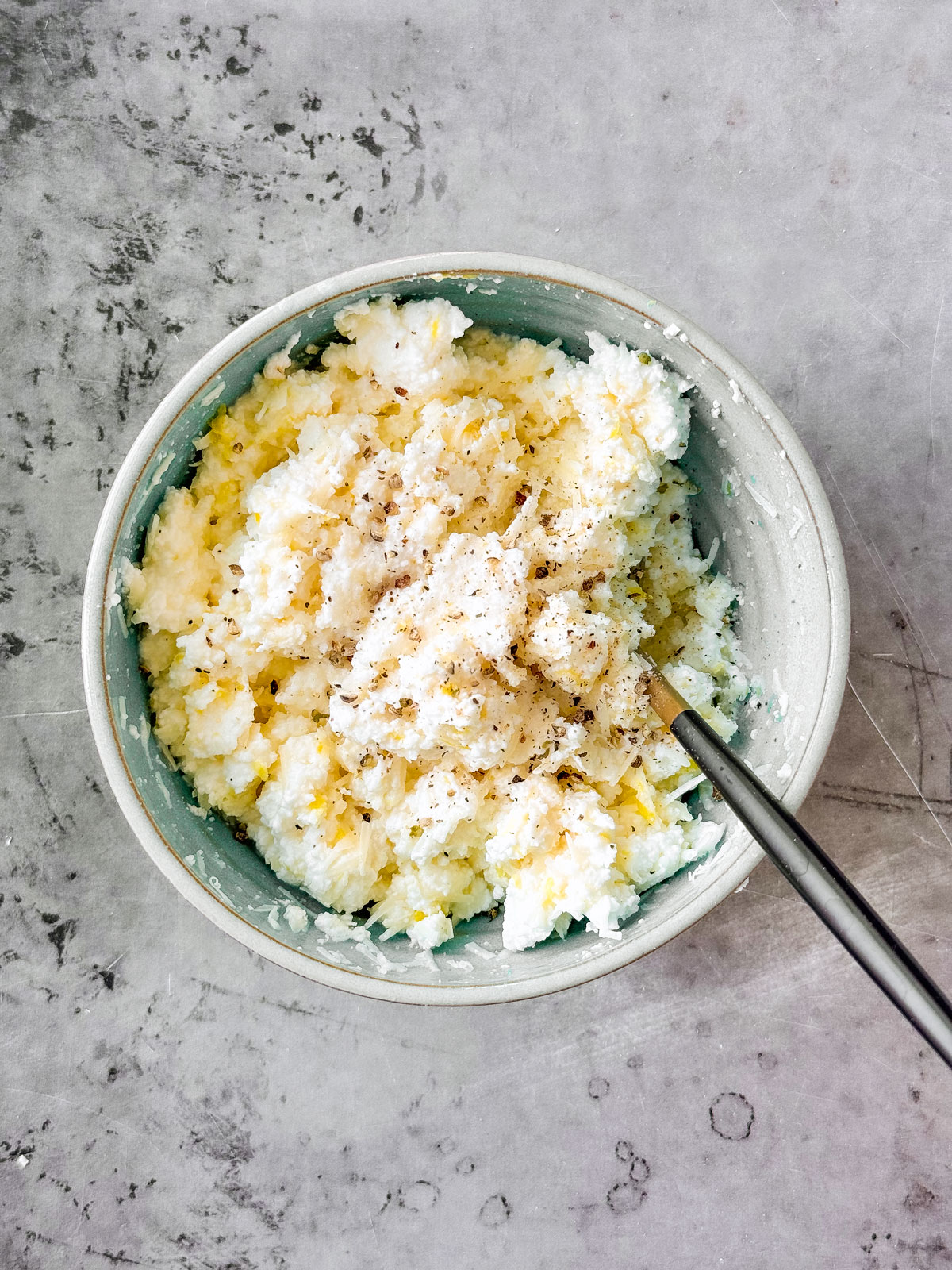 Lemon ricotta mixture in a small mixing bowl.