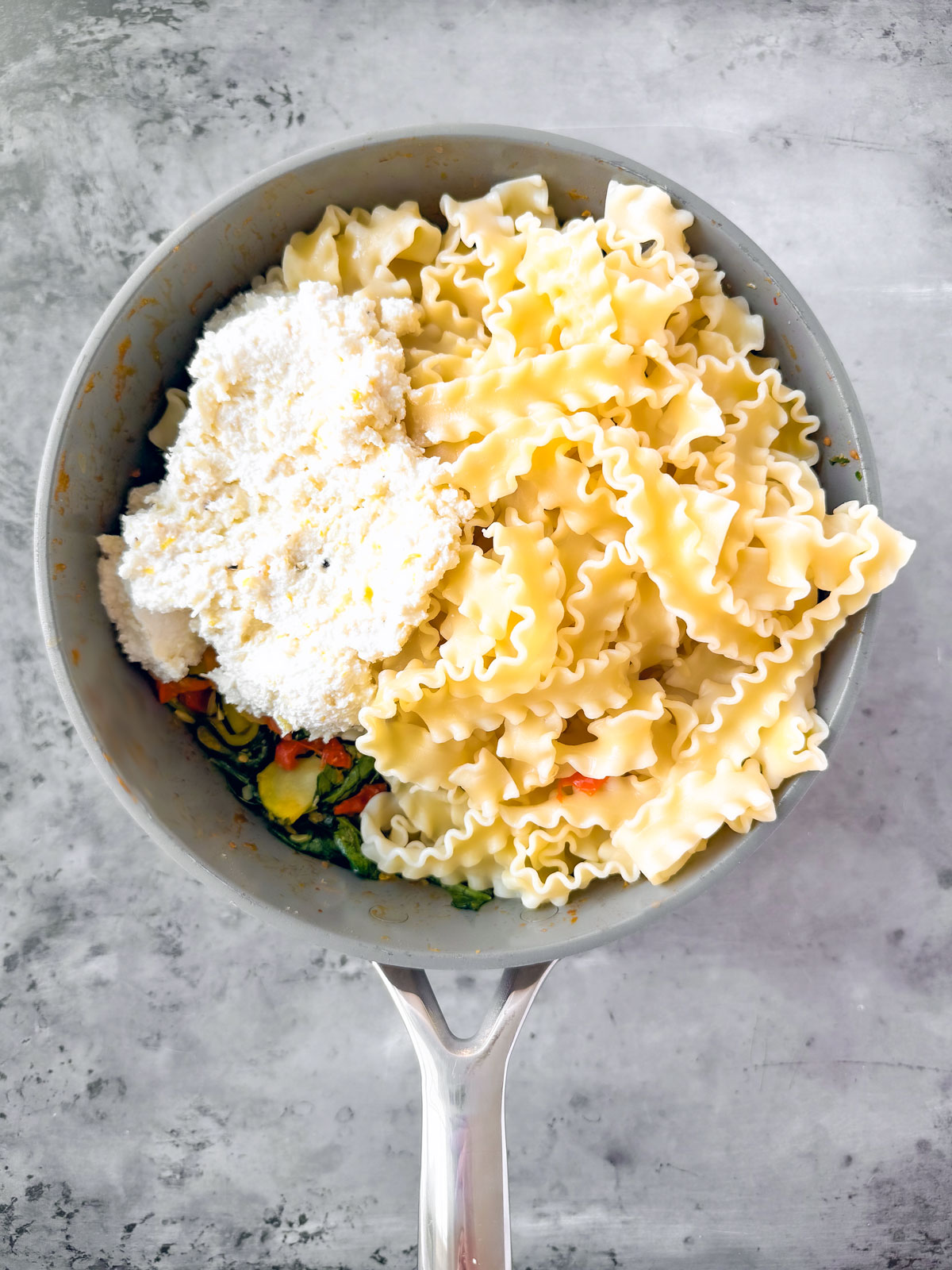 Pasta and ricotta mixture added to the pan of veggies.