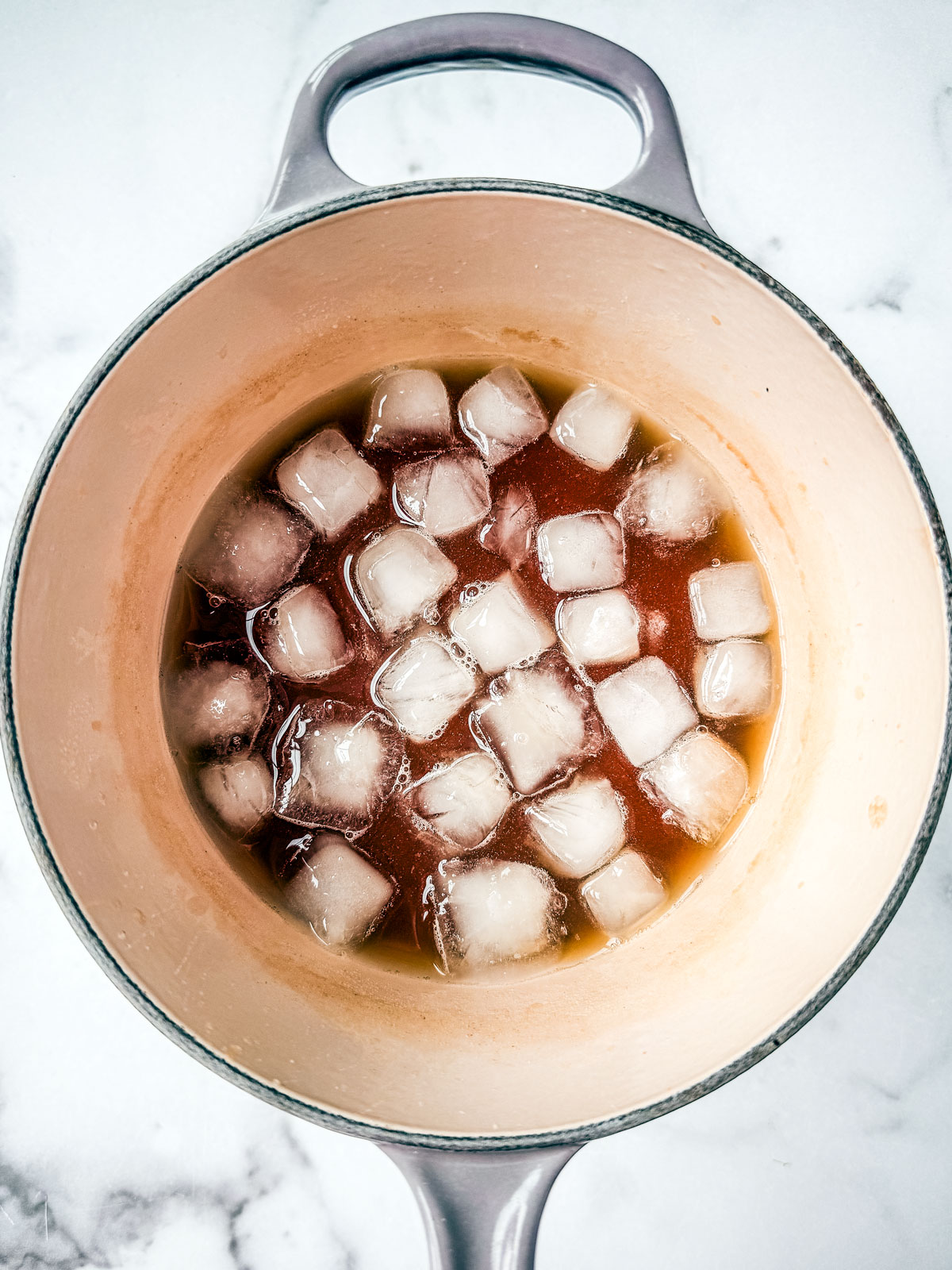 Saucepan with brine and ice cubes in it.