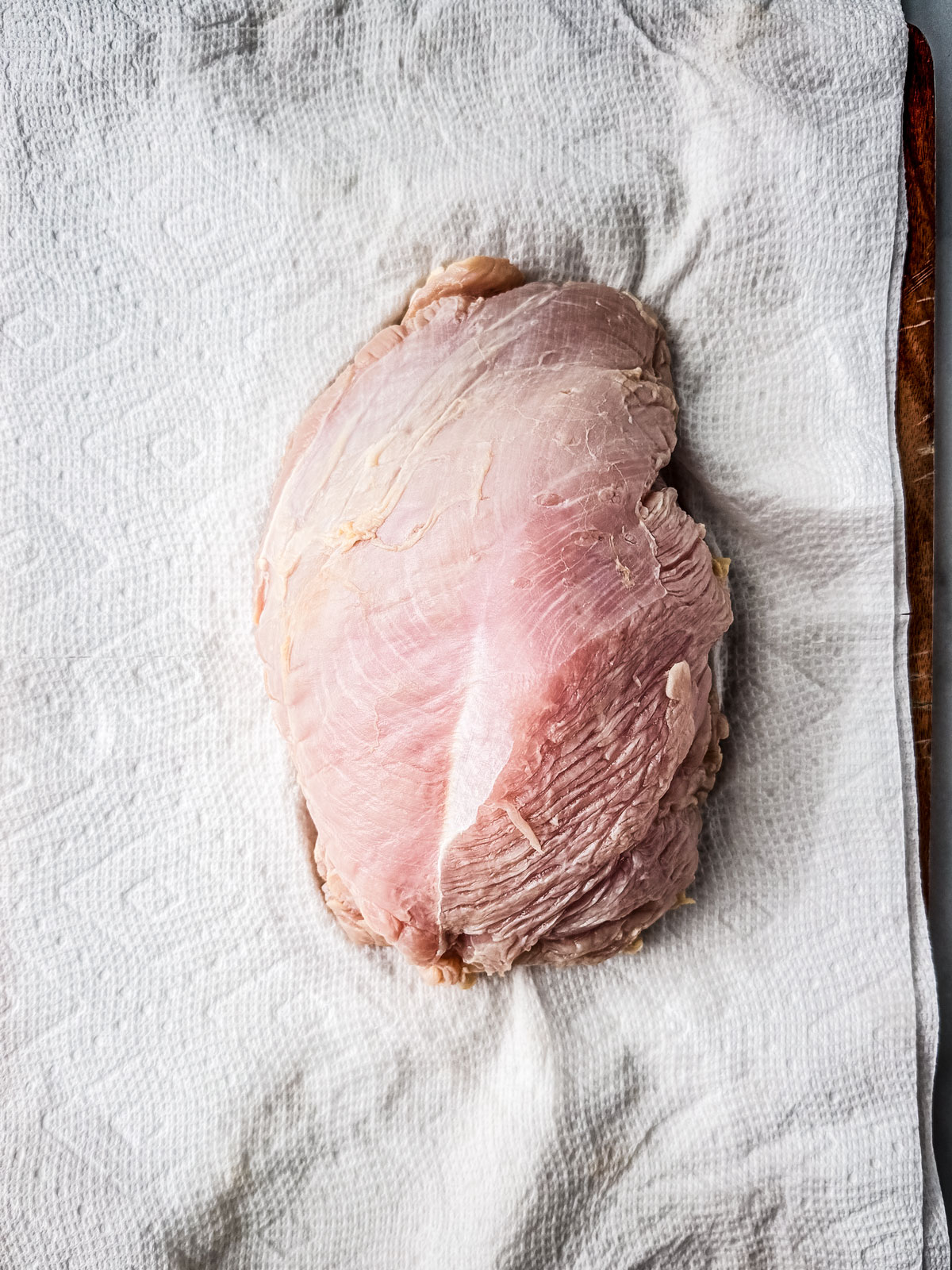 Turkey breast on a paper towel-lined cutting board.