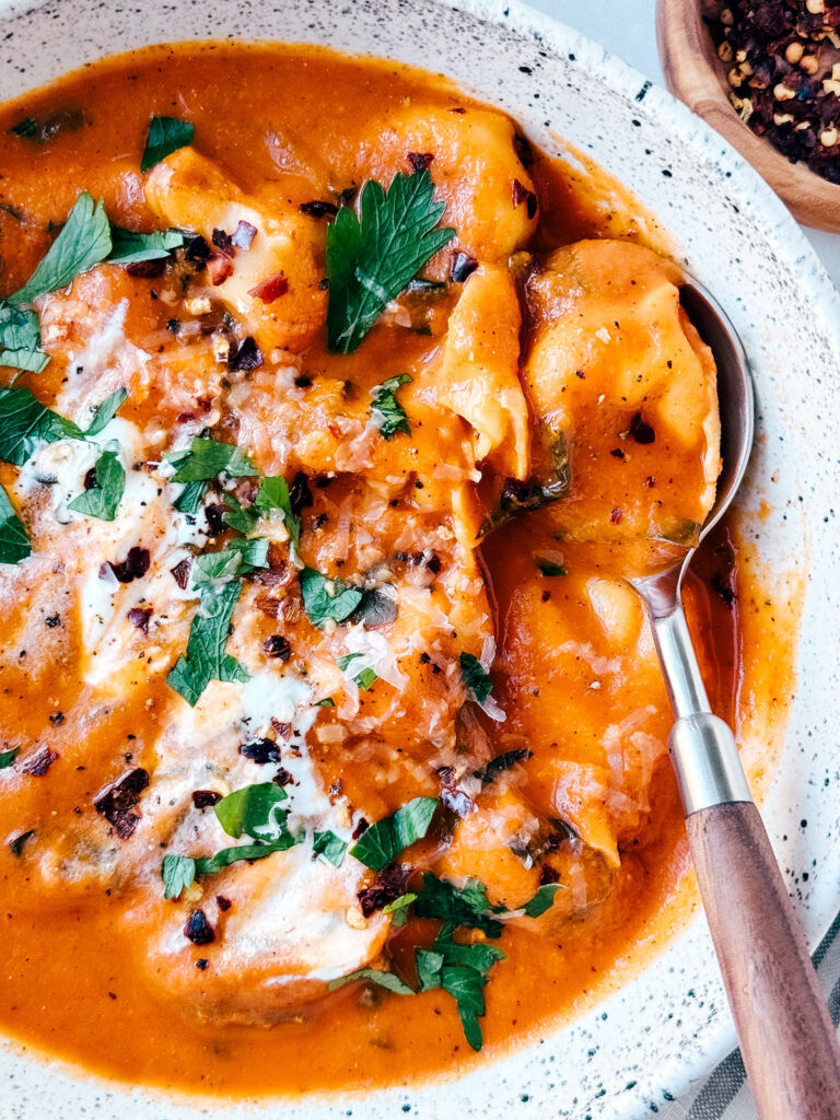 Close up of creamy tortellini soup in a bowl.