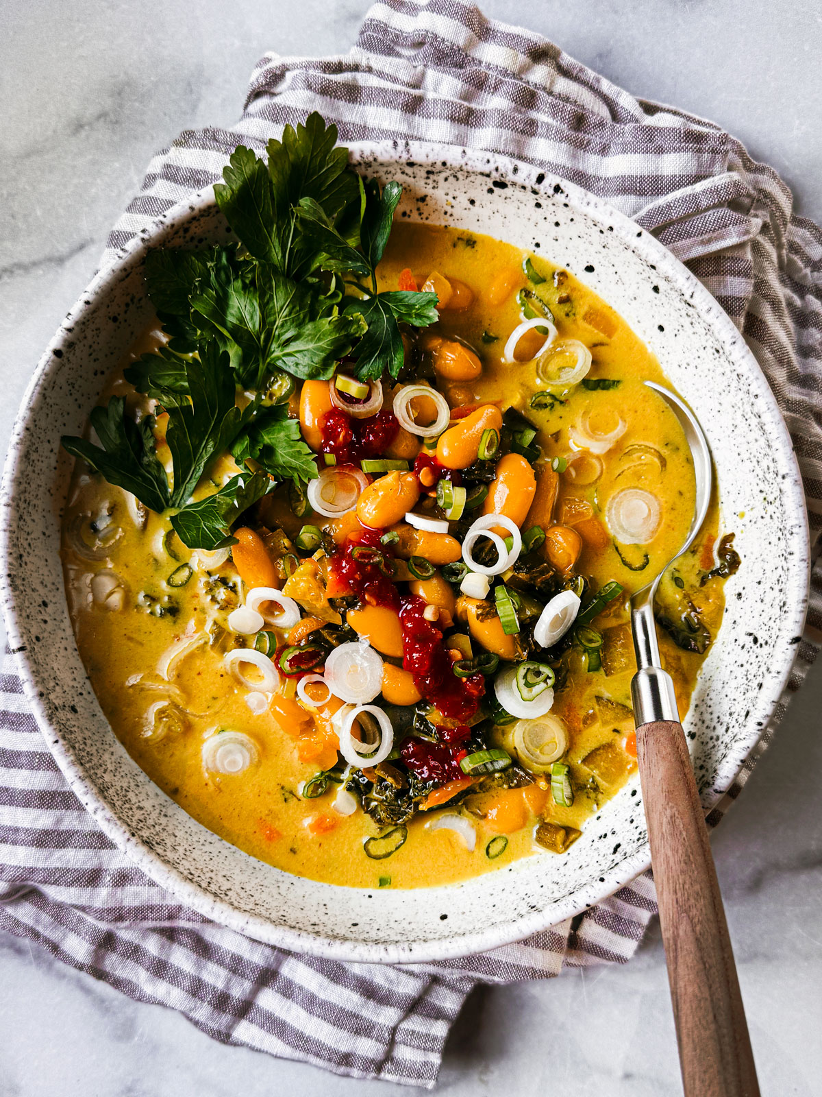 Bowl of kale and white bean Thai curry soup.