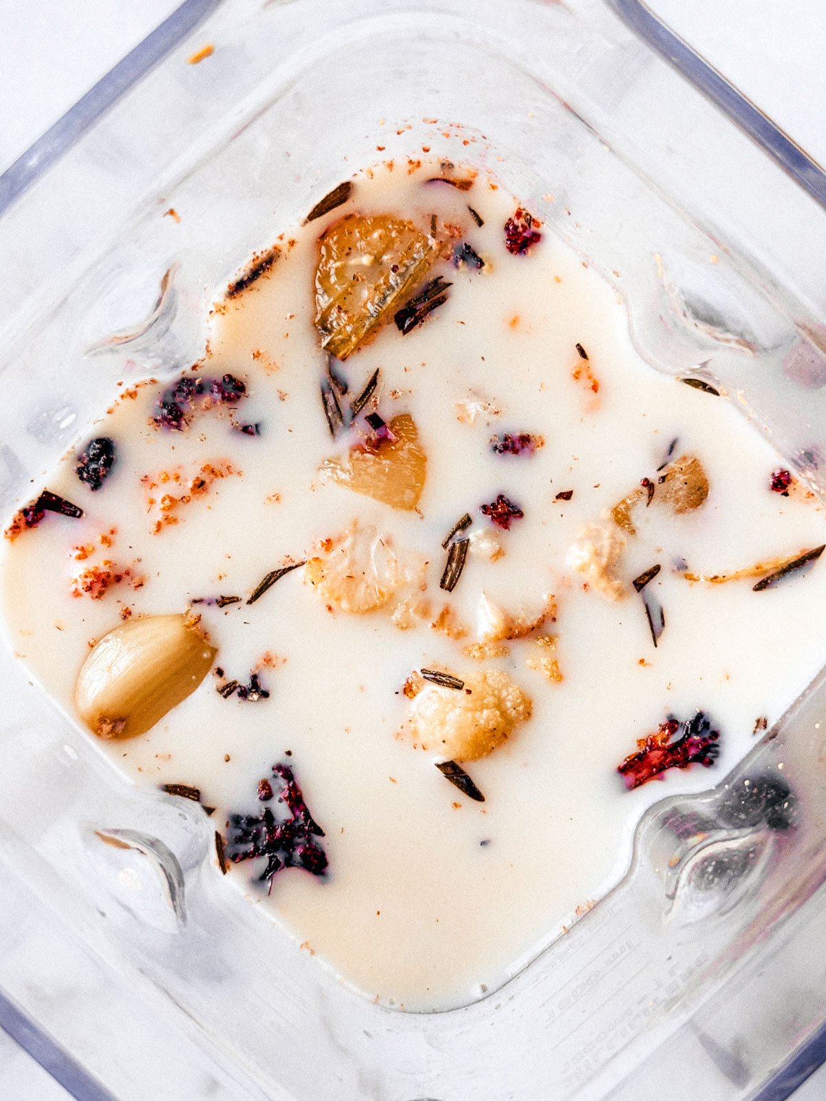 All of the roasted cauliflower soup ingredients in a blender before being blended.