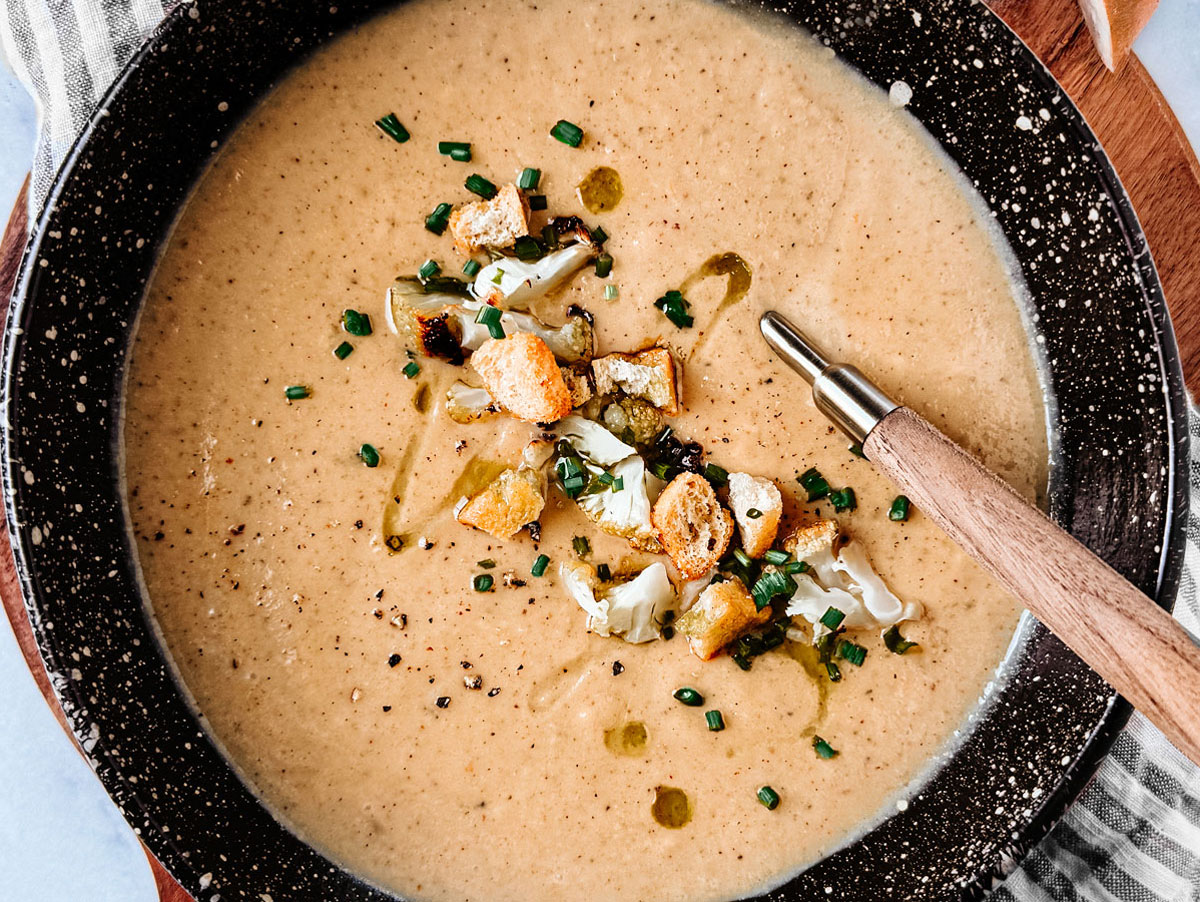 Bowl of roasted cauliflower soup with cheese.