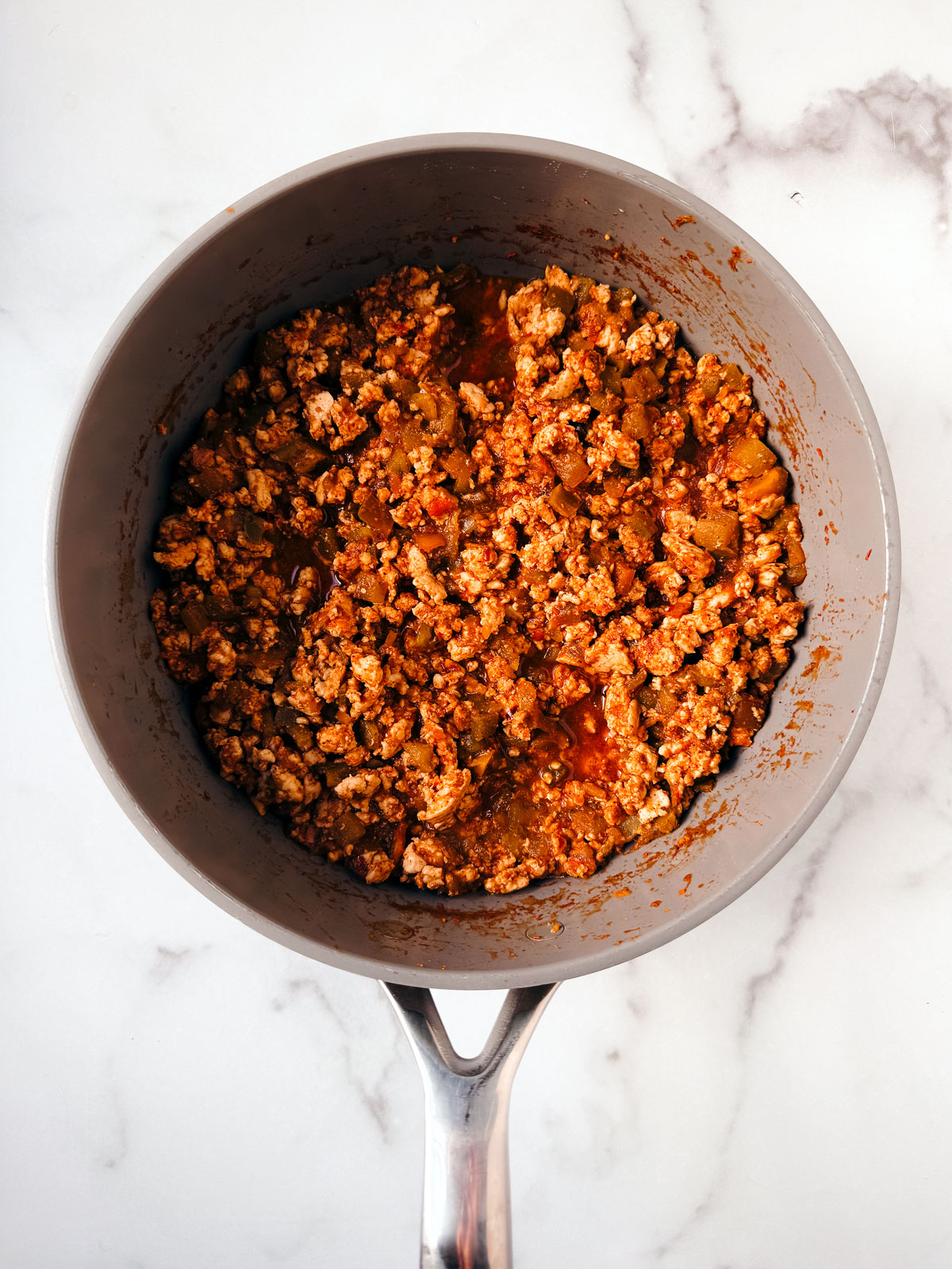 Taco meat mixture mixed and cooked in a pan.