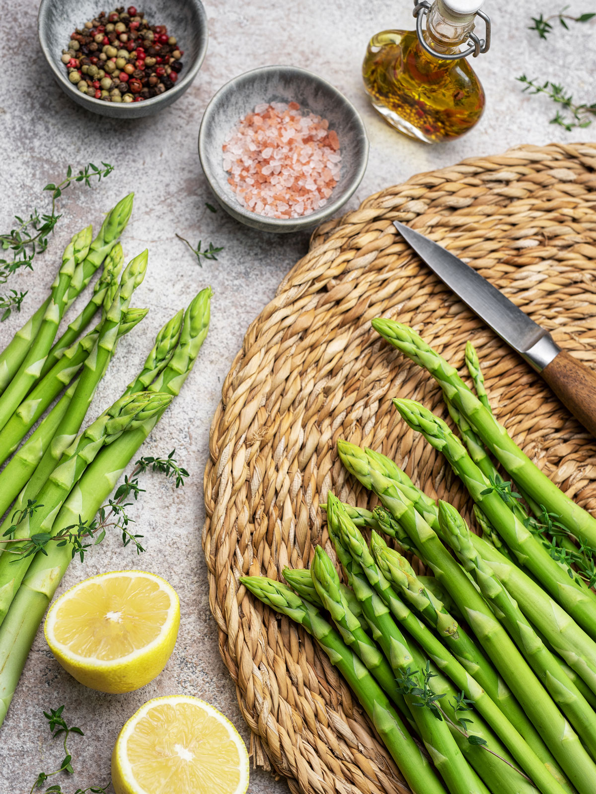 Asparagus on a countertop with a knife.