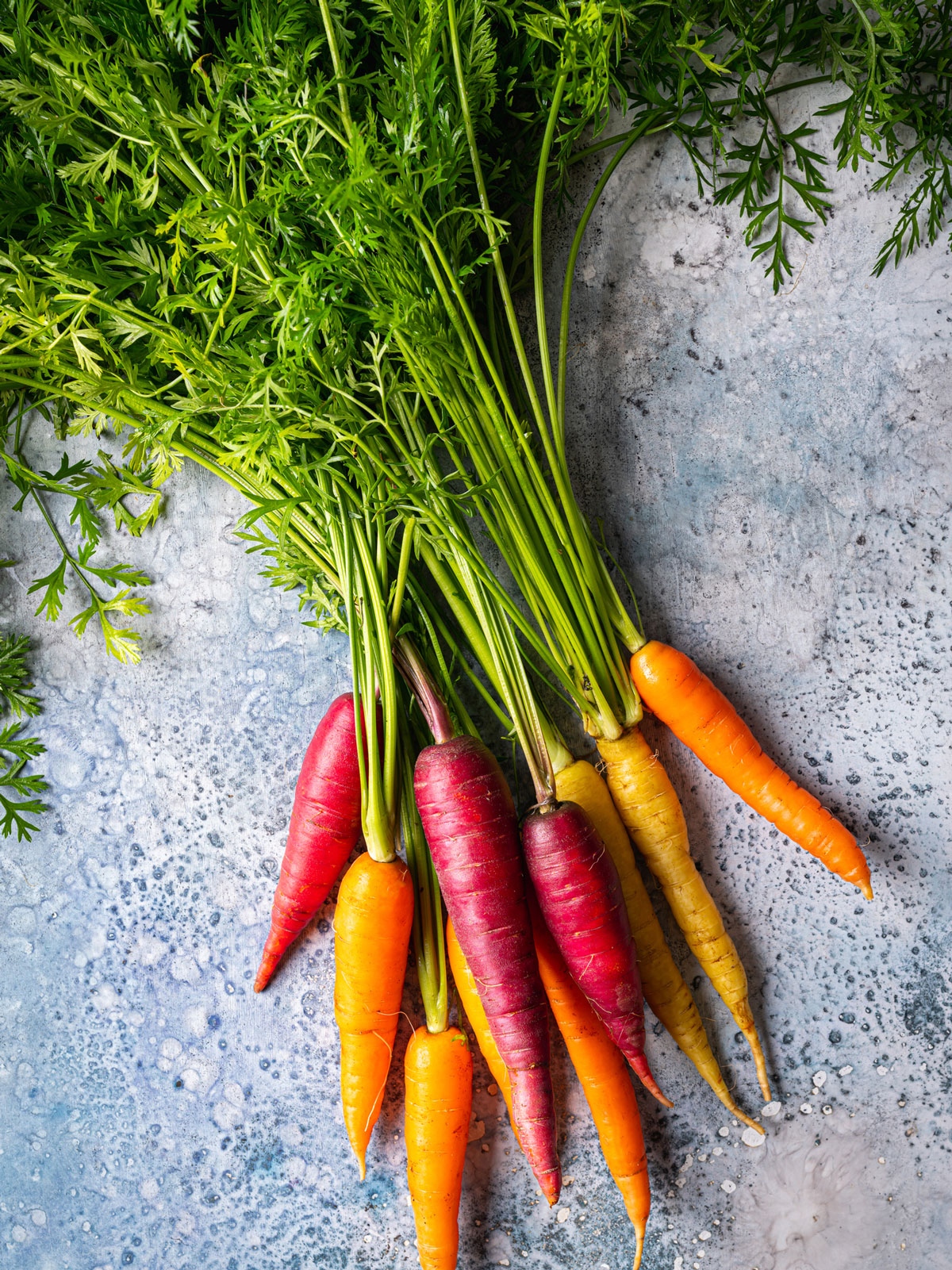 Colorful carrots on a stone table.