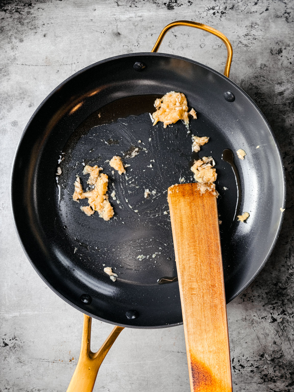 Pan with garlic and ginger being sautéed.