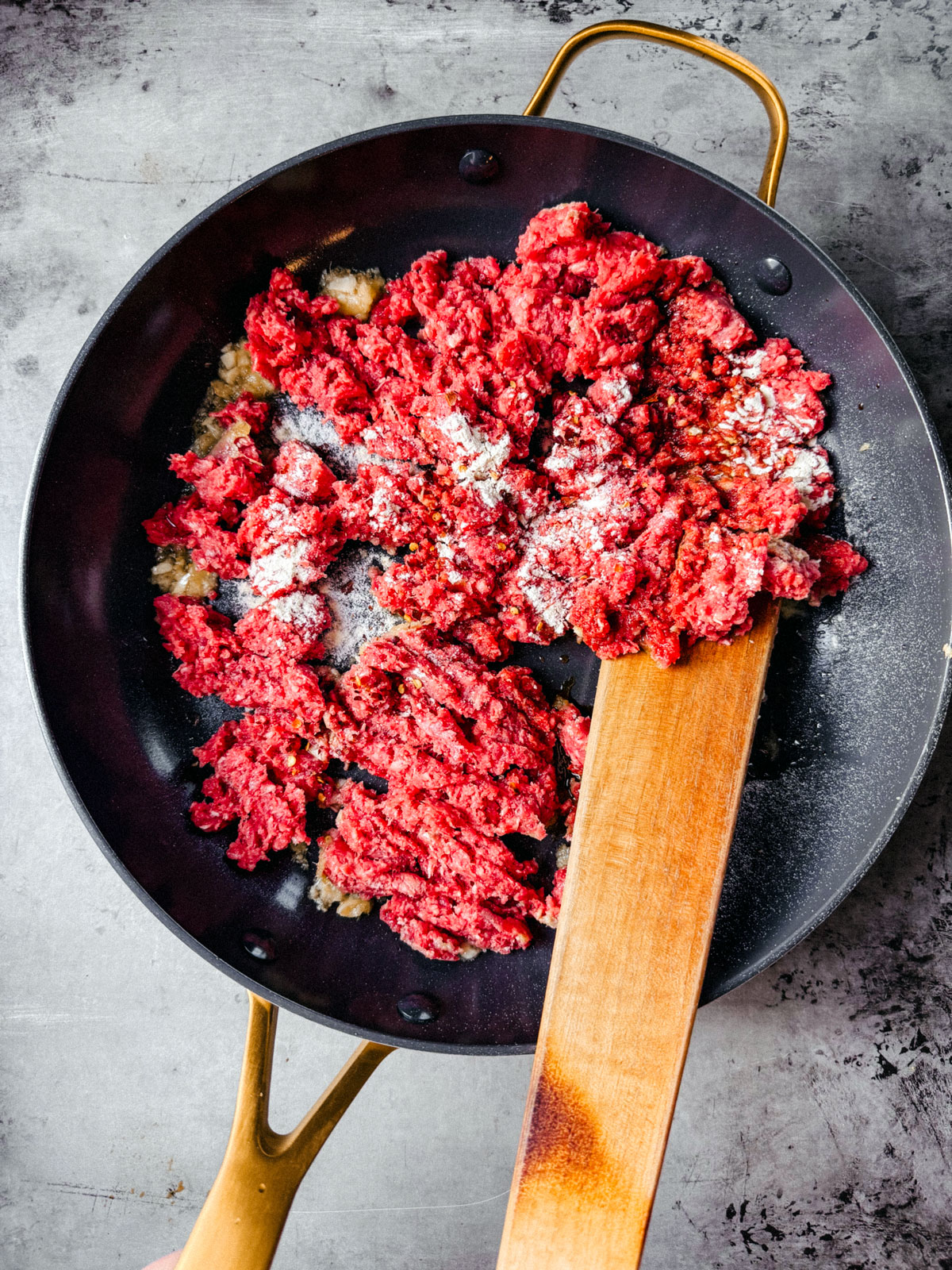 Pan with ground beef and seasonings in it.