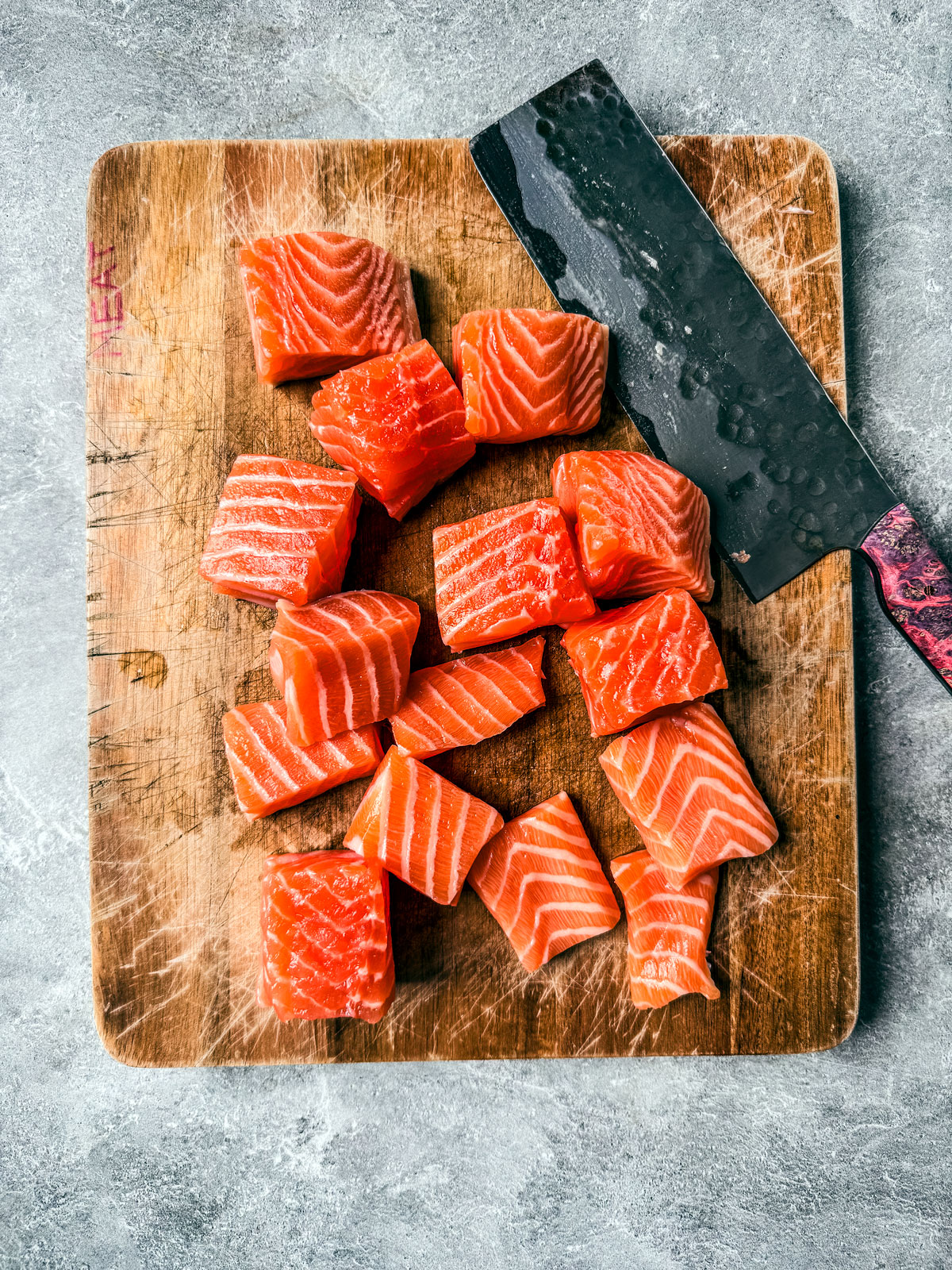 Cubed salmon on a cutting board.