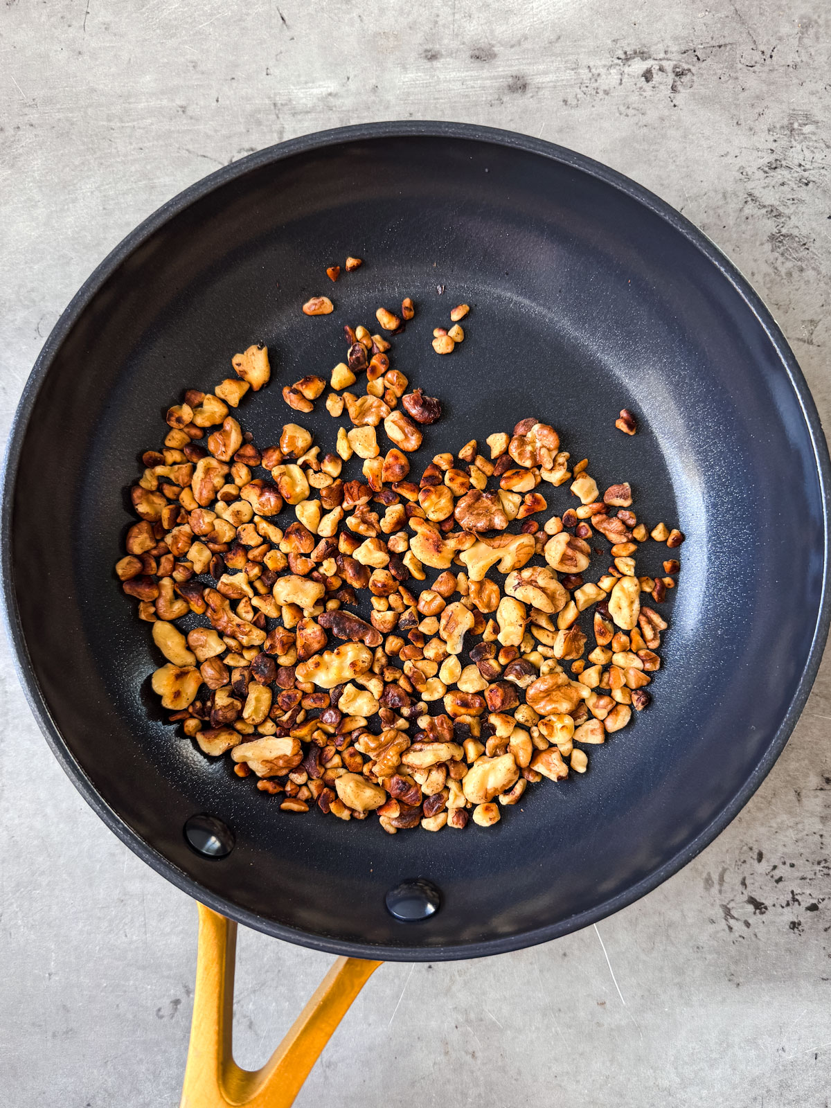 Toasted walnuts in a pan.