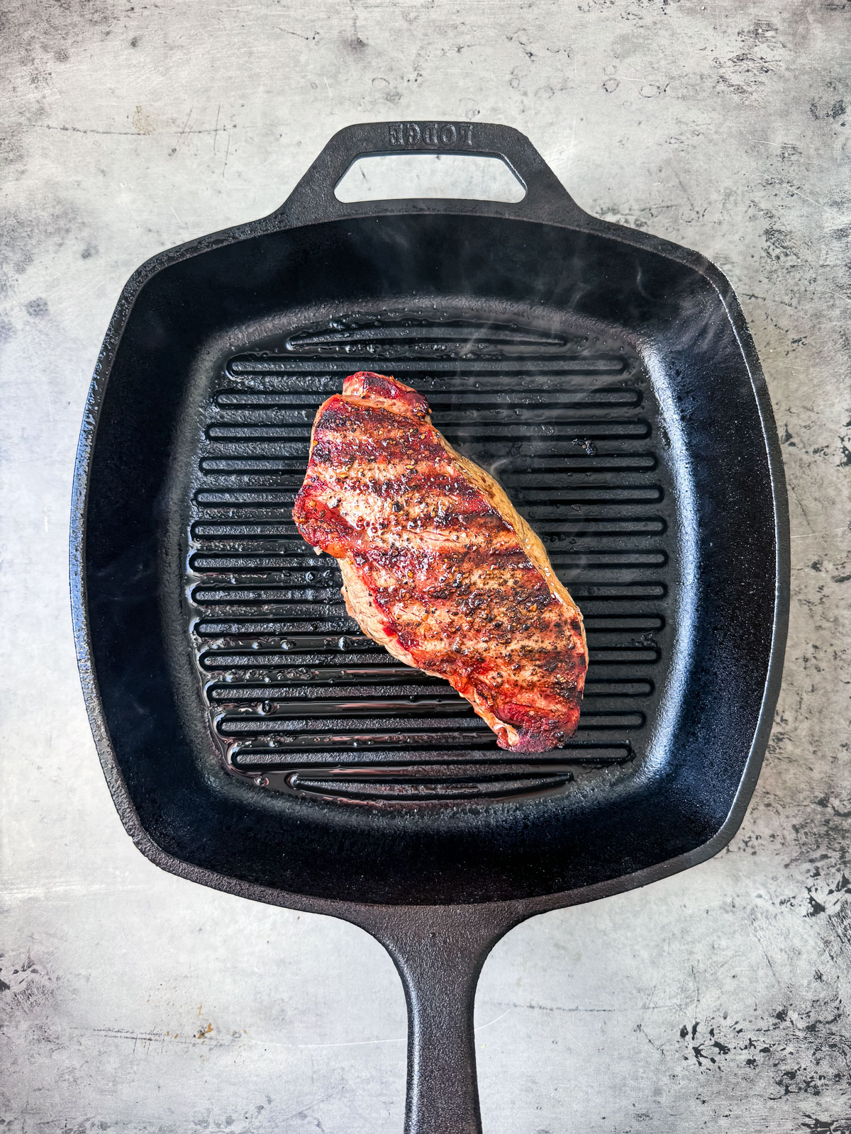 Steak on a grill pan with nice grill marks.