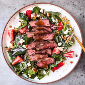 Strawberry Spinach Salad With Steak drizzled with maple balsamic dressing.