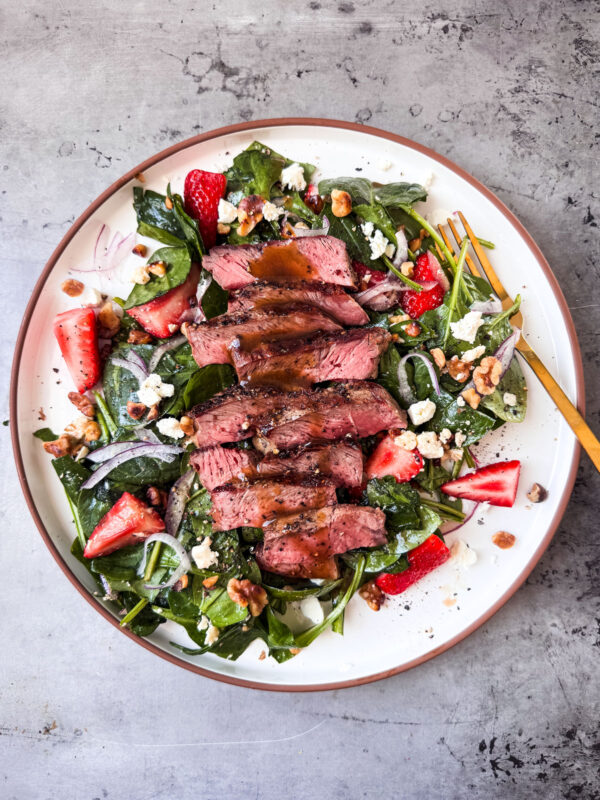 Strawberry Spinach Salad With Steak drizzled with maple balsamic dressing.