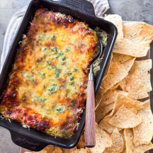 Baked spinach and artichoke cottage cheese dip with tortilla chips.